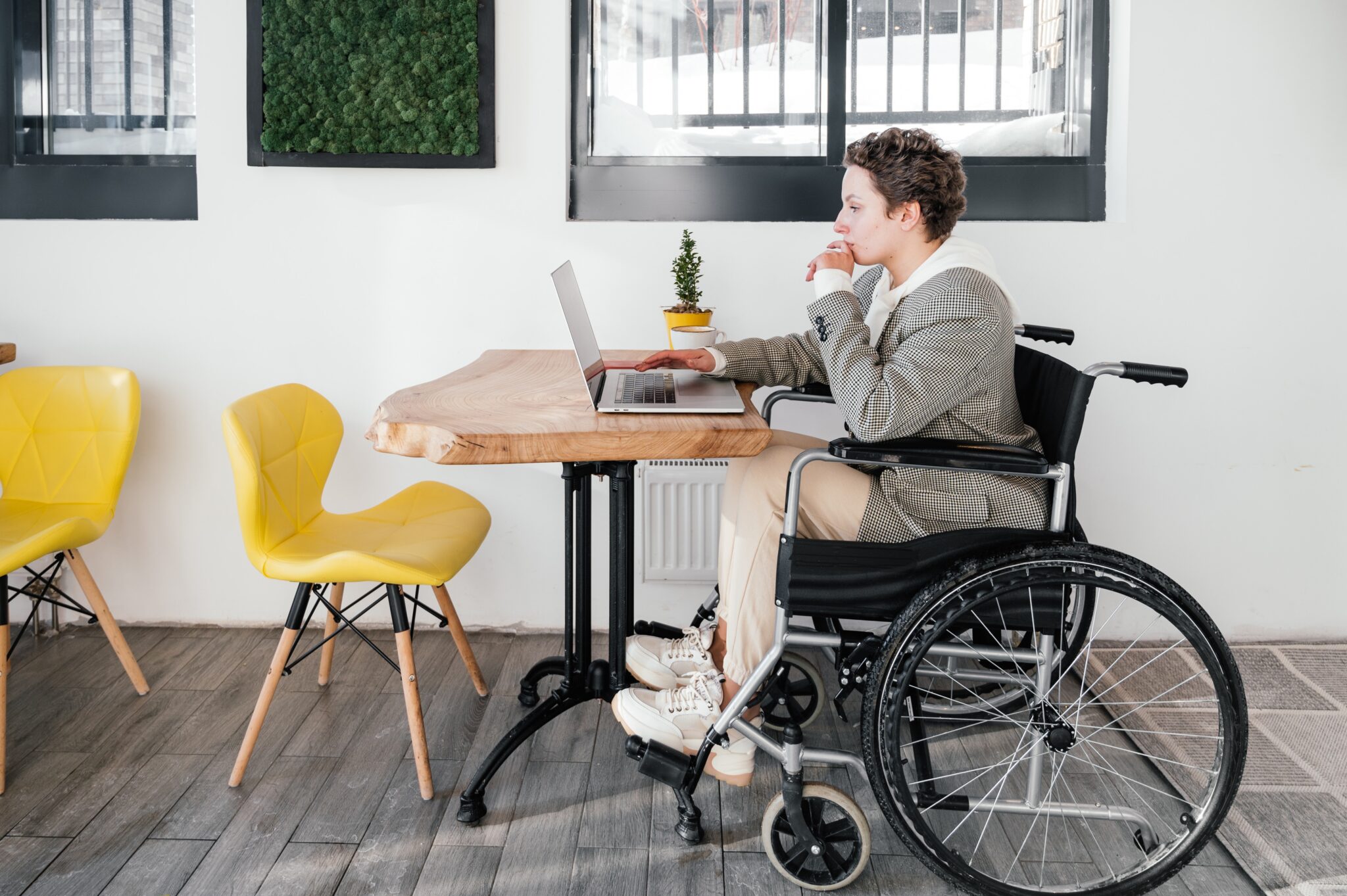 a person in a wheelchair uses a laptop