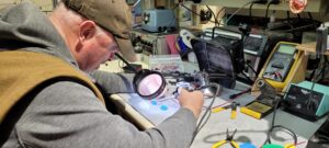 A man solders a device at the Vancouver Hack Space.