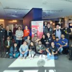 Full Circle staff showing off their adapted toys in a group photo, along with Neil Squire staff, guests, Executive Director Gary Birch, and BC Minister of Jobs, Economic Development and Innovation Brenda Bailey.