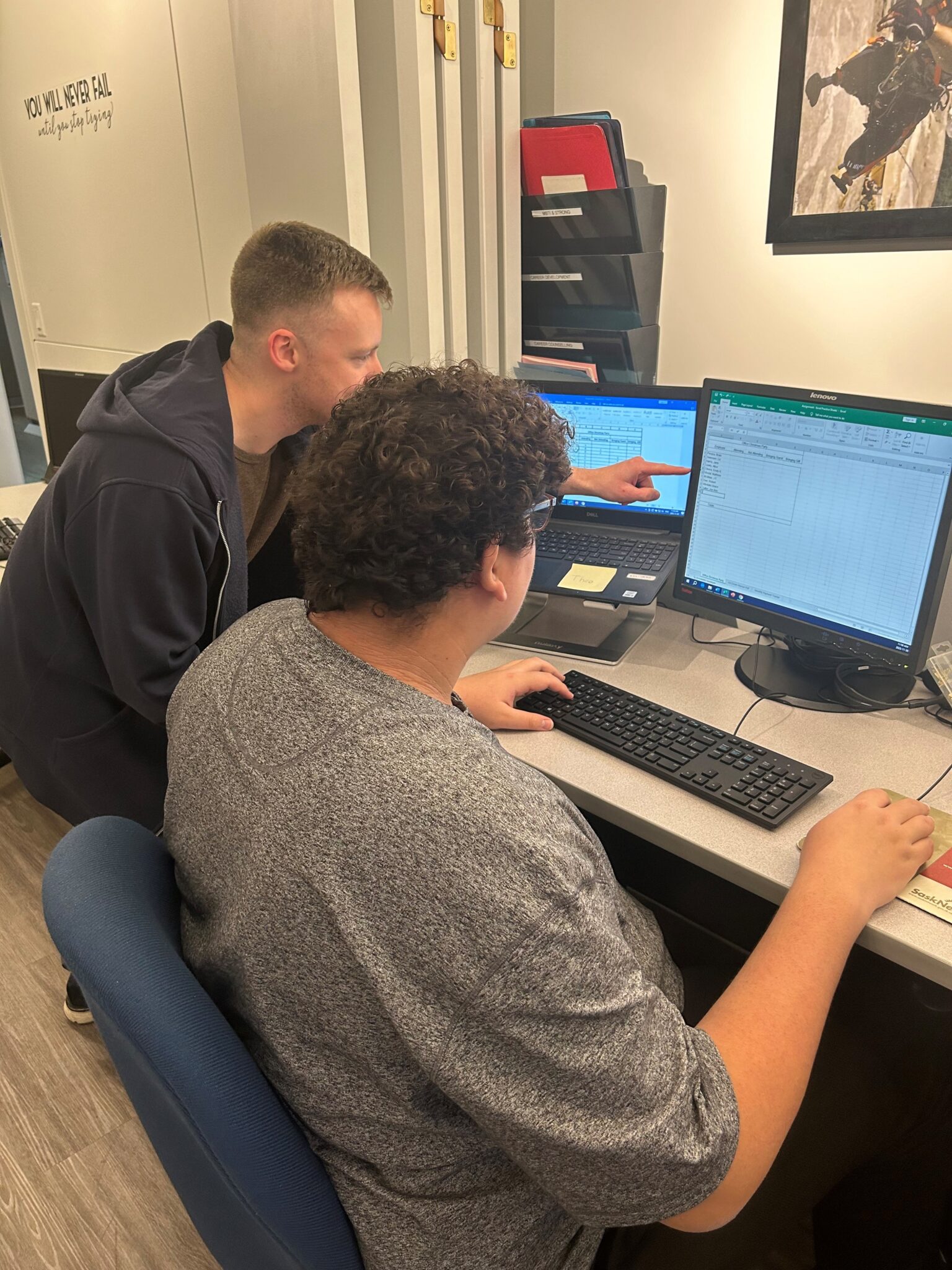 Theoren (right) works on the computer, while getting guidance from his Job Developer, Patrick (left).