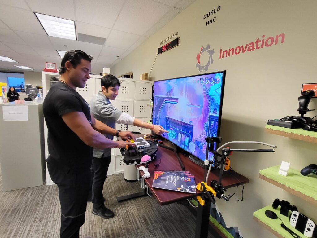 MMC team member Kyle shows Tyson Gillies an adaptive gaming demo.