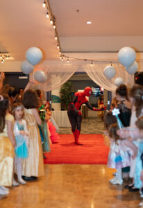 A Spiderman performer greets the children upon entering the ballroom.