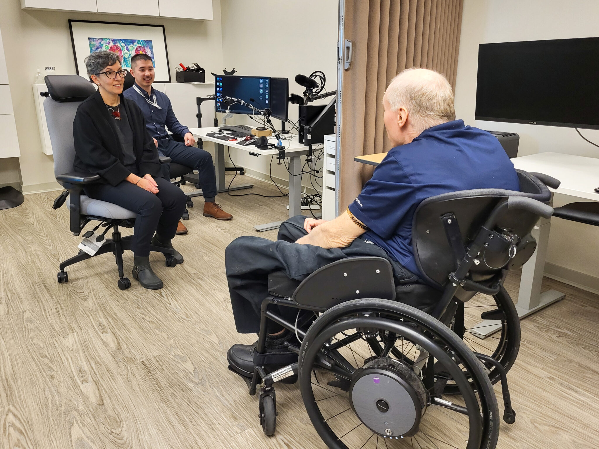 Nisa Tummons talking with Neil Squire Executive Director Gary Birch, and Solutions occupational therapist Eric Chau.