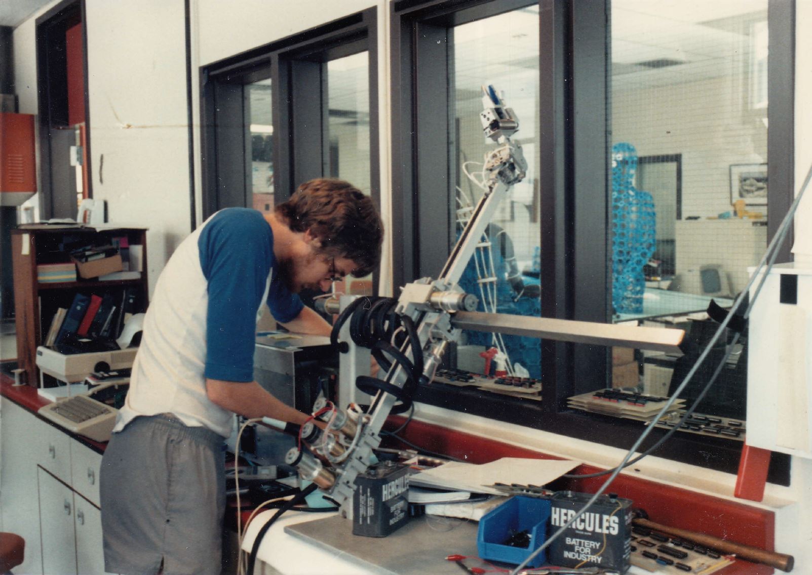 A person works on a device in our robotics R&D lab in the 1980's.