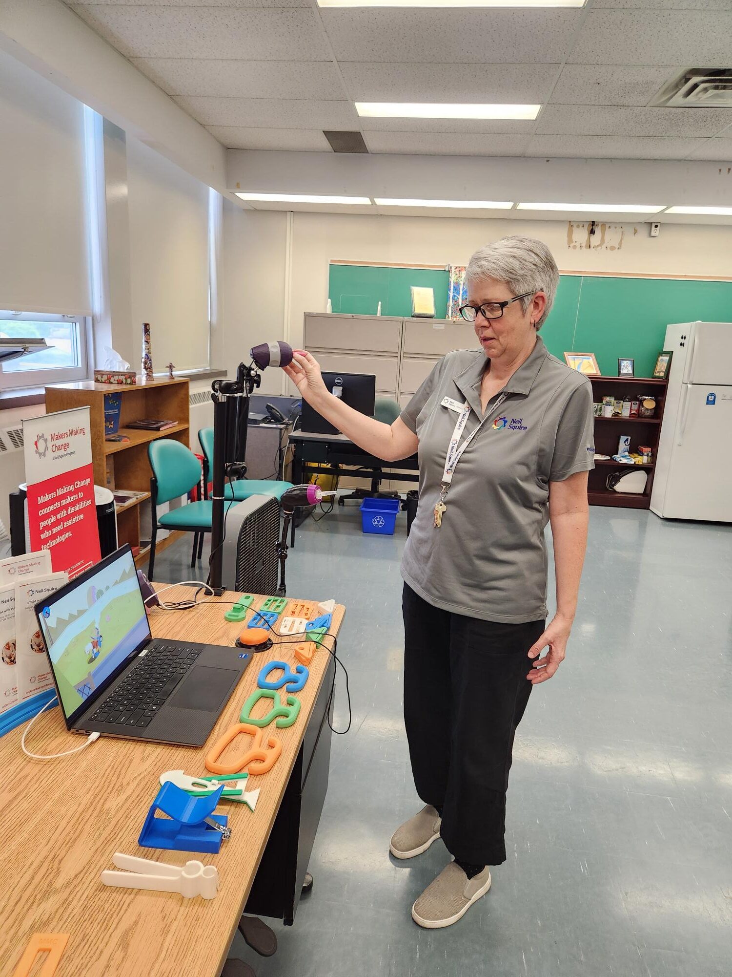 Cheryl looks at a Makers Making Change display with 3D printed assistive technology.