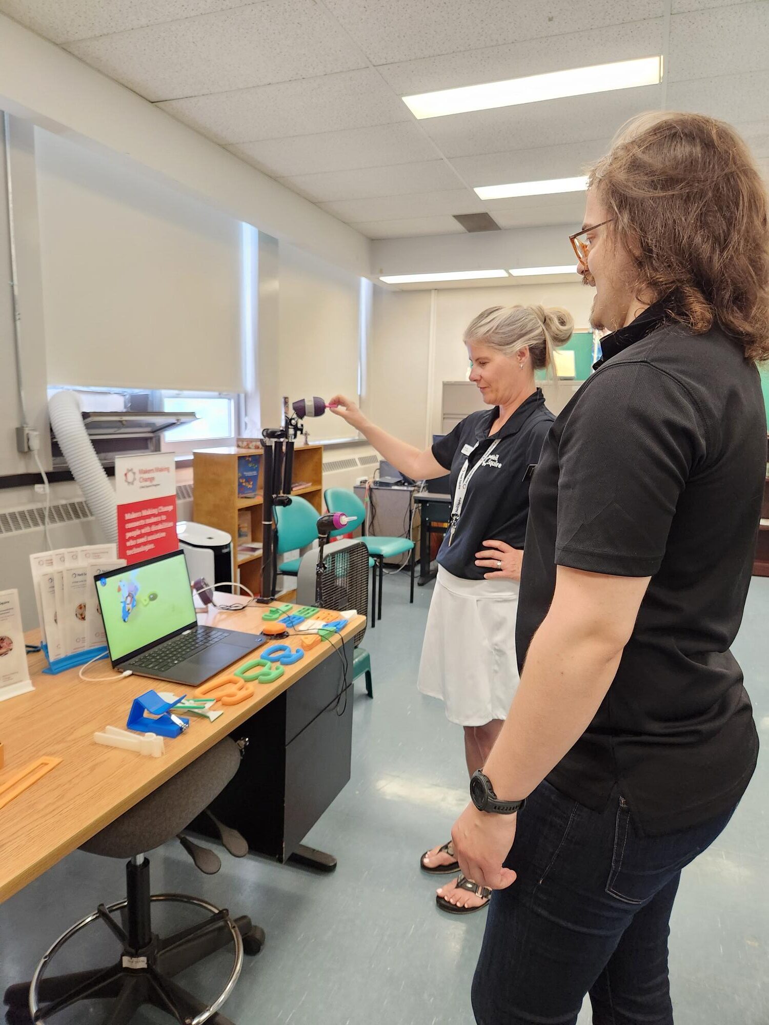 Stephan and Loni look over the Makers Making Change assistive technology display.