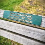 The plaque on the bench that says, 