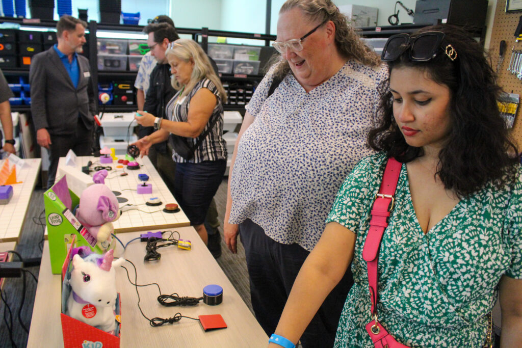 Partygoers tour the Makers Making Change office with adapted toys on display.