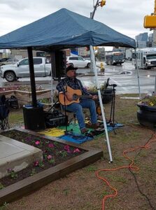 The Lone Rambler playing guitar at the barbecue.