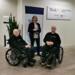 Occupational Therapist Katrina Tilley holds her award, standing next to Executive Director Gary Birch and National Operations Manager Greg Pyc in the Neil Squire office.