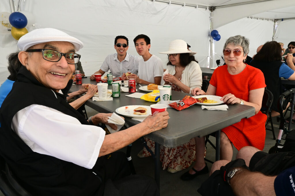 Longtime supporters and members from the community enjoy a bite to eat under the tent.