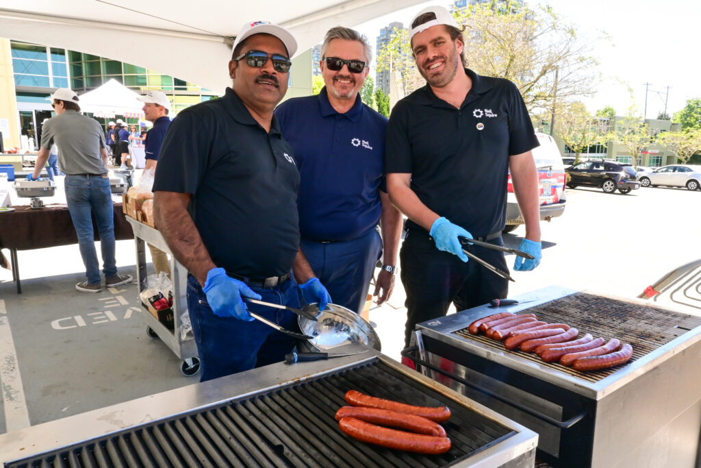 Neil Squire staff Munesh, Nate, and Reed grill some hot dogs.