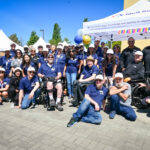 Neil Squire staff all pose together next to the Neil Squire tent outside the Burnaby office.