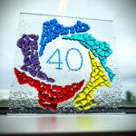 A stained glass art of our logo with the number 40 inside.