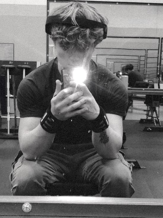 A black and white selfie taken by Blake in a gym.