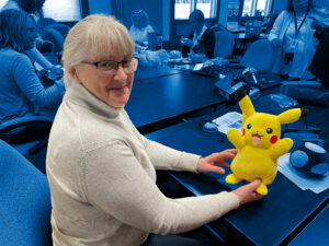 A volunteer works on adapting a Pikachu toy at a Makers Making Change build event.