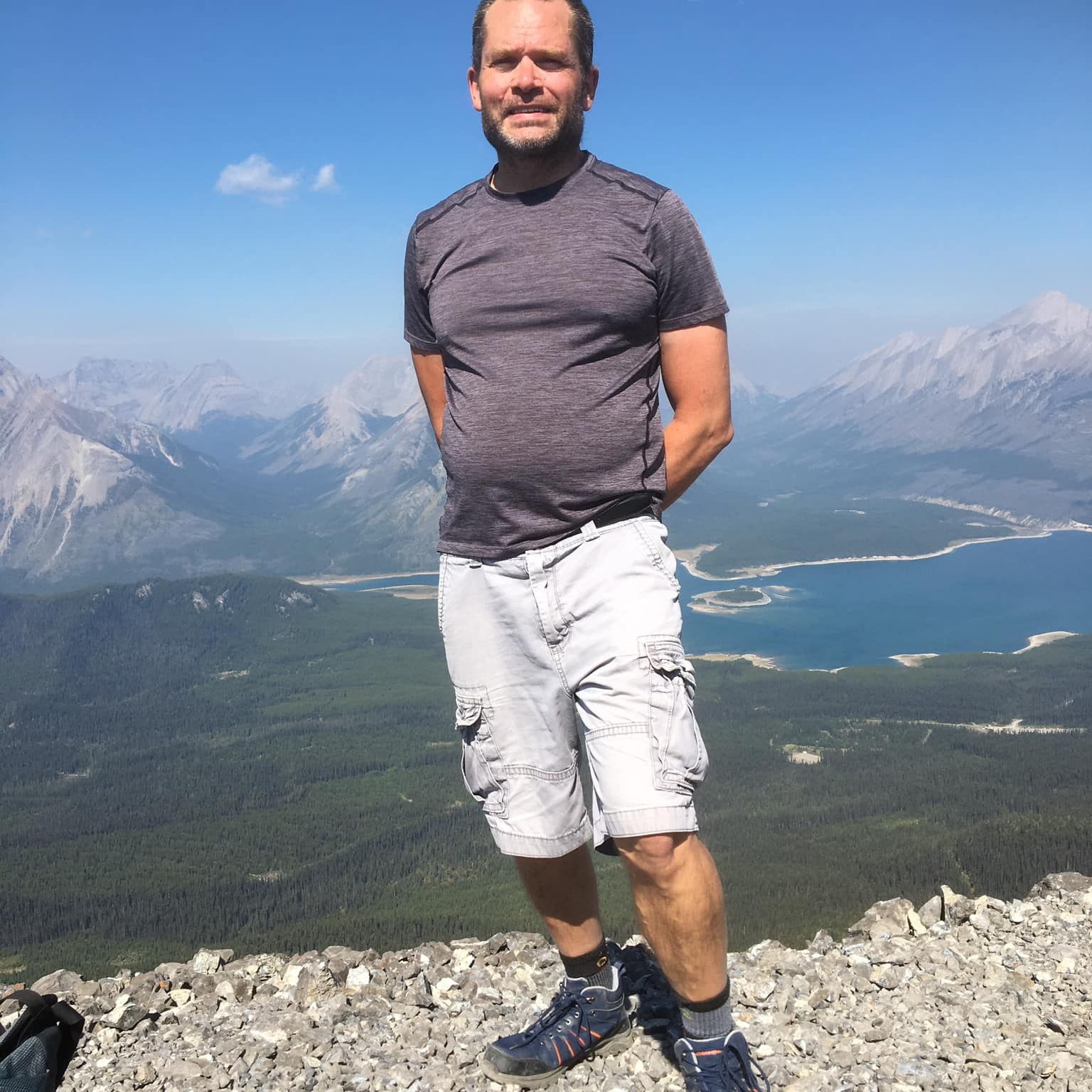 Jesse standing in front of a scenic view of a mountain valley