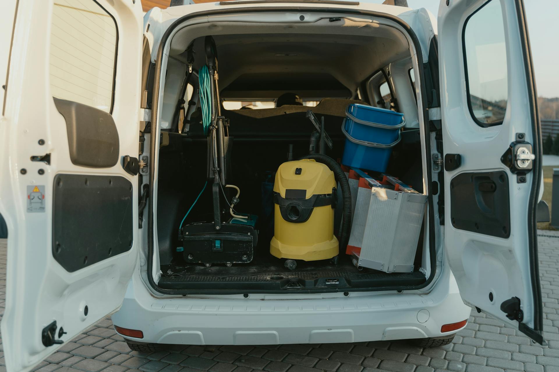 An open van with cleaning tools inside.