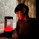 A boy watches his red switch adapted Volcano Lamp toy.