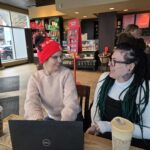 Kennedy (left) talks with Shannel (right) at a cafe.