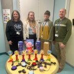 Natalie (second from left) delivering adapted toys to clinicians at Janeway Children's Health and Rehabilitation Centre.