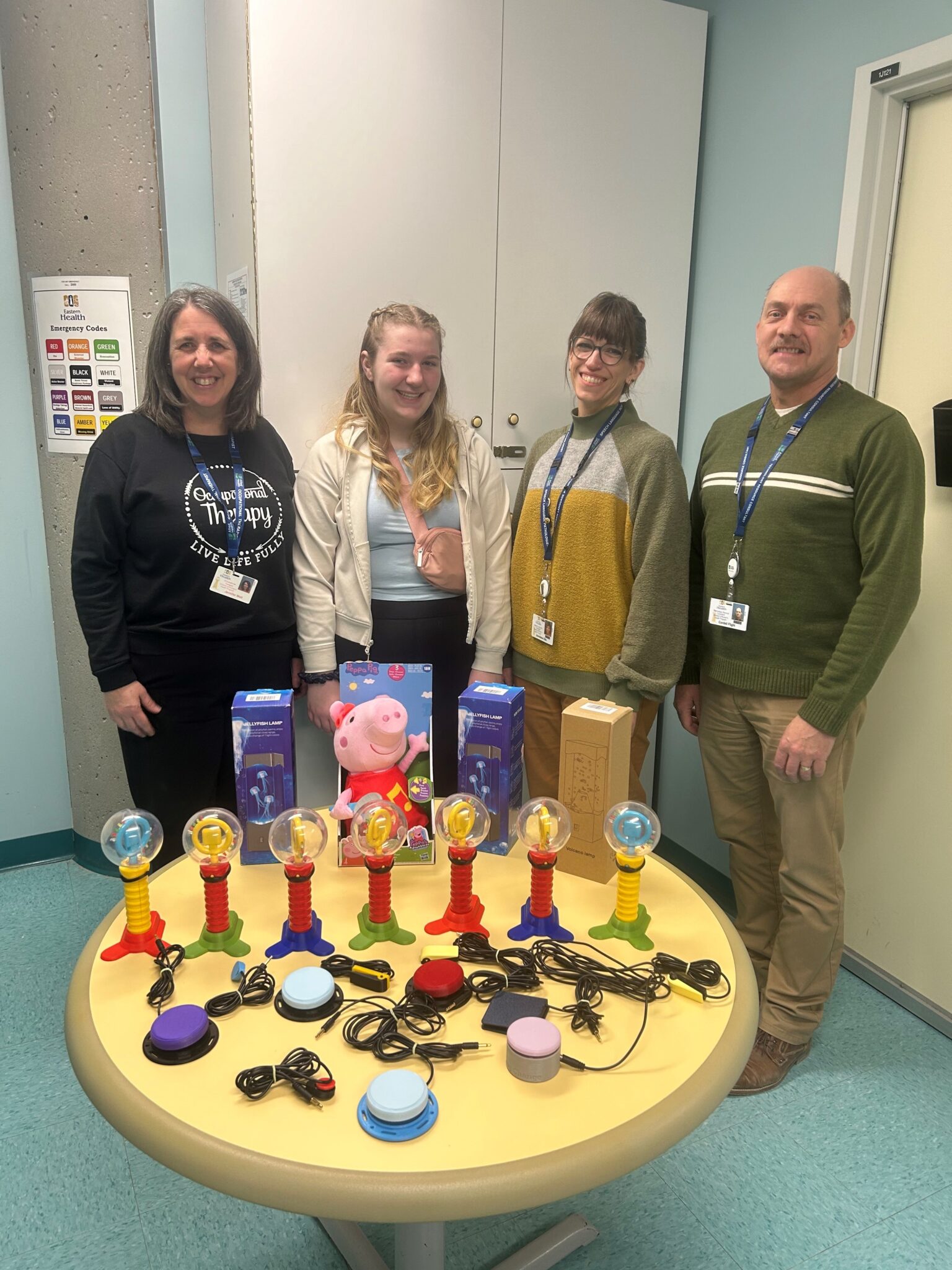 Natalie (second from left) delivering adapted toys to clinicians at Janeway Children's Health and Rehabilitation Centre.