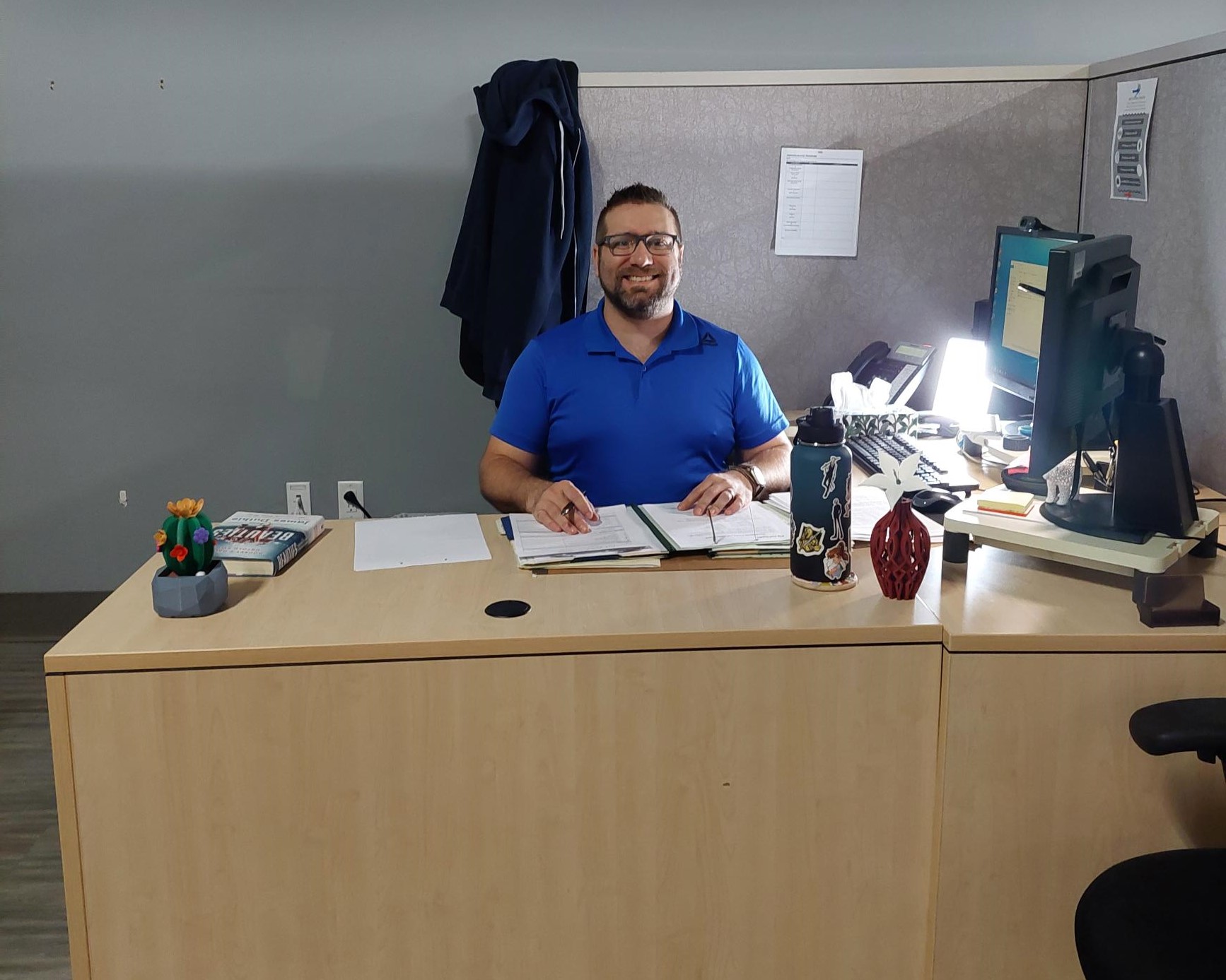 Brad sitting at his desk at his new workplace.