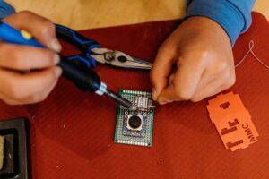 A person does some soldering at a build event.