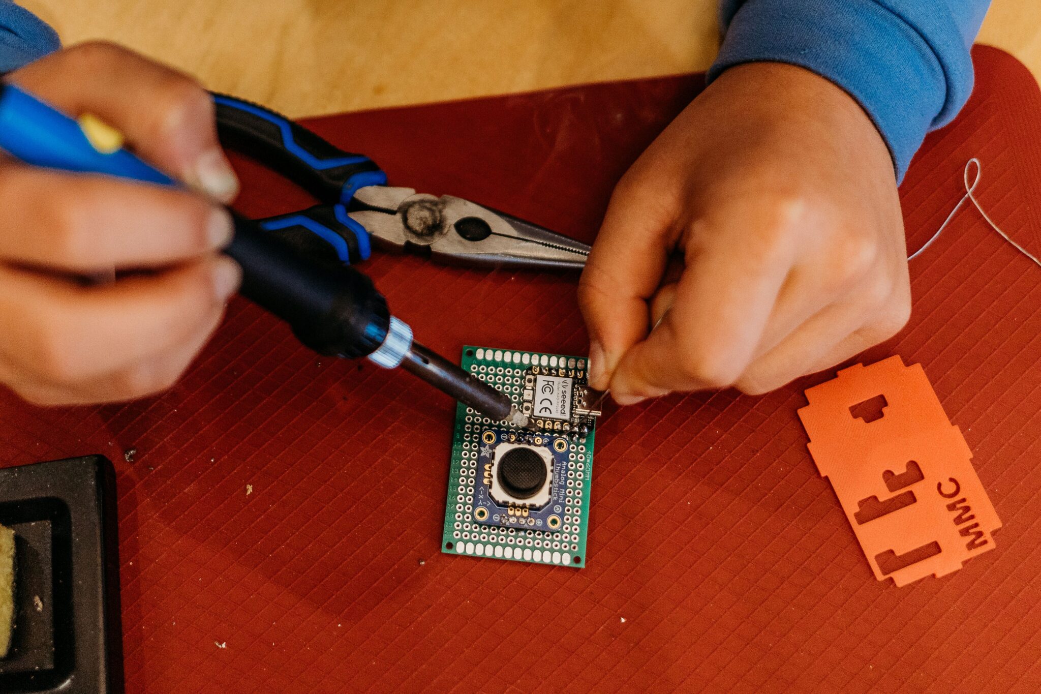 A person does some soldering at a build event.